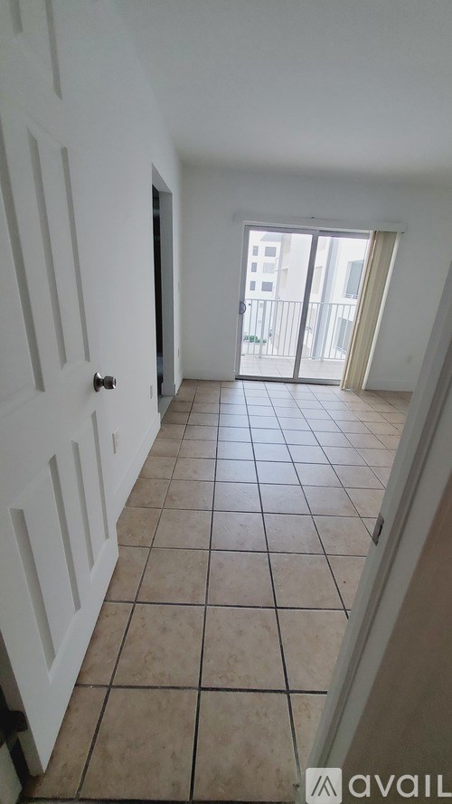 A hallway with tiled floors and white walls.
