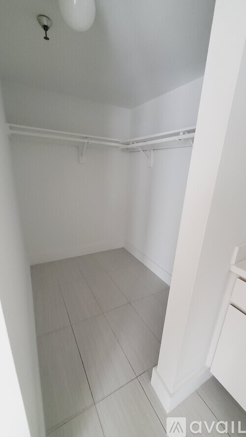 A small white bathroom with a toilet and a shower.