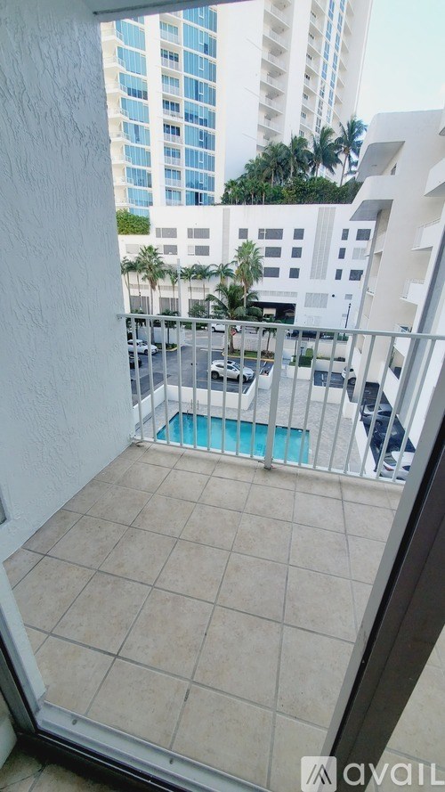 A balcony with a pool and a view of a cityscape.