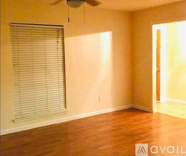 A room with a fan and a window with blinds.