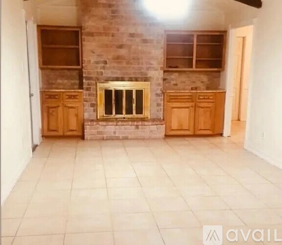 A room with a fireplace and wooden cabinets.