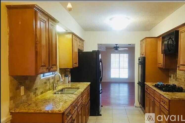 A kitchen with wooden cabinets and granite countertops.