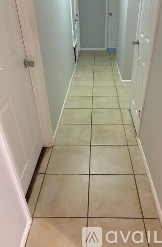 A hallway with tiled floors and white walls.