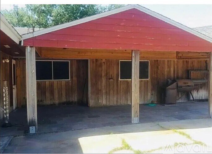 A red-roofed wooden building with a concrete floor.