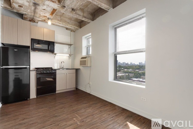 A kitchen with black appliances and wooden floors.
