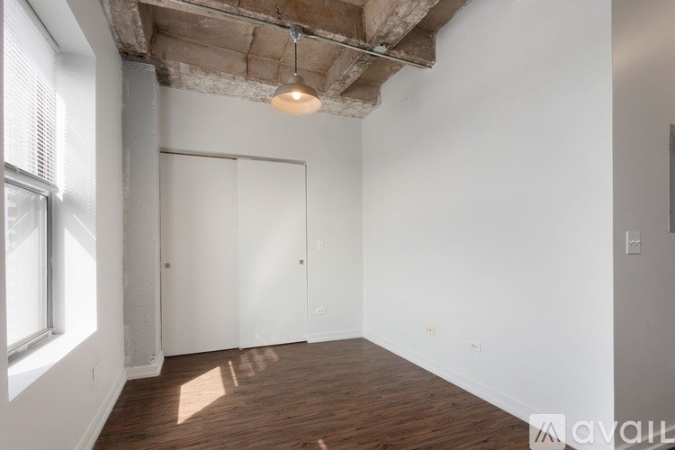 A room with a wooden floor and a ceiling with exposed beams.