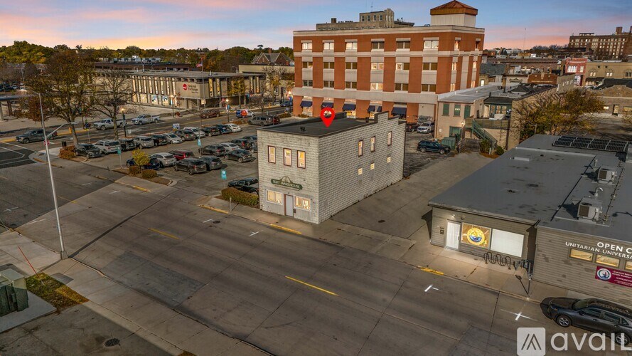 A parking lot with a building in the background and a sign that says "Open".