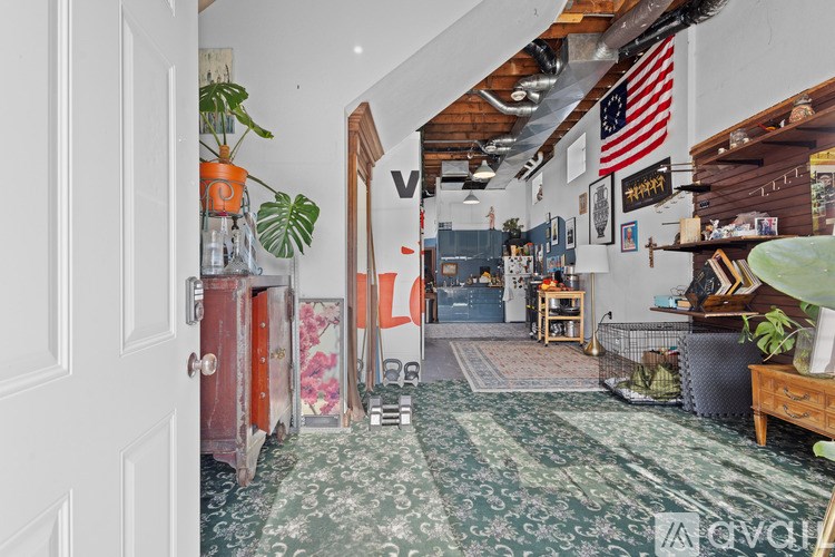 A room with a rug on the floor and a door on the left.