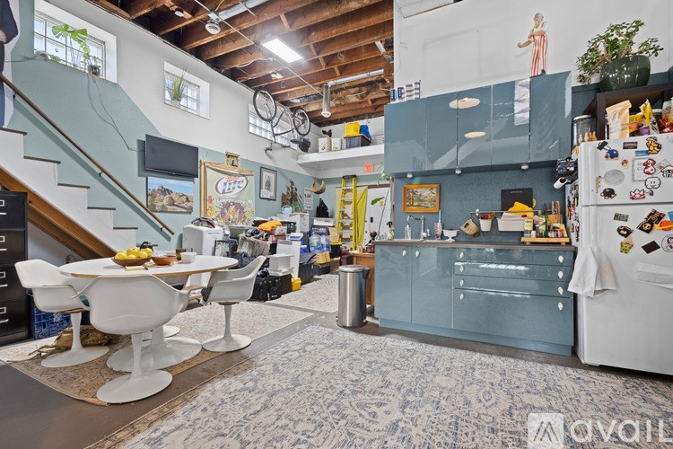 A kitchen with a blue refrigerator and white chairs.