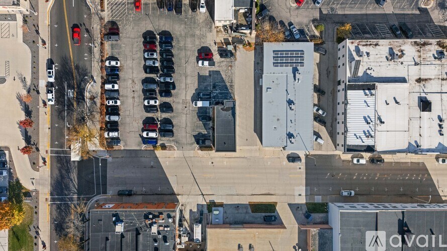 A parking lot with cars and a building in the background.