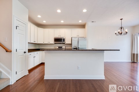 A kitchen with white cabinets and a black countertop.