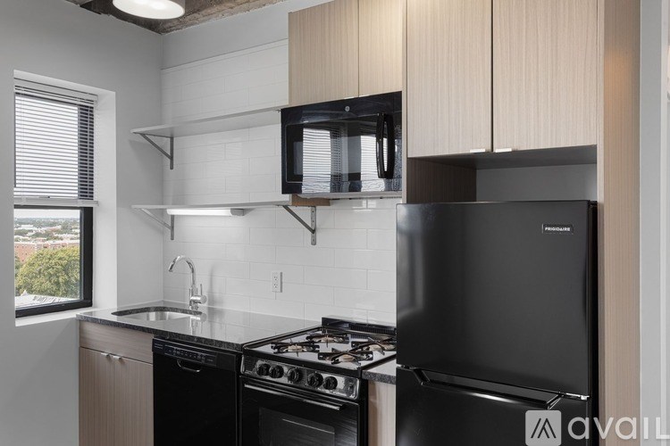 A kitchen with black appliances and white cabinets.