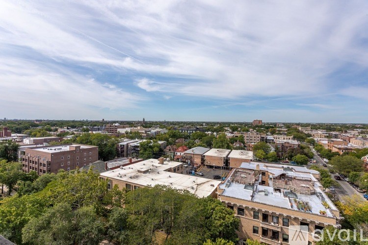 A cityscape with buildings and trees under a cloudy sky.
