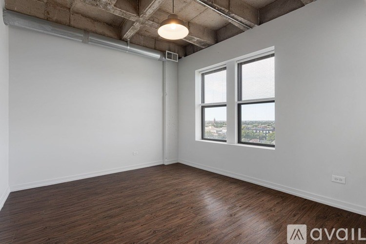 A room with wooden floors and a window overlooking a cityscape.