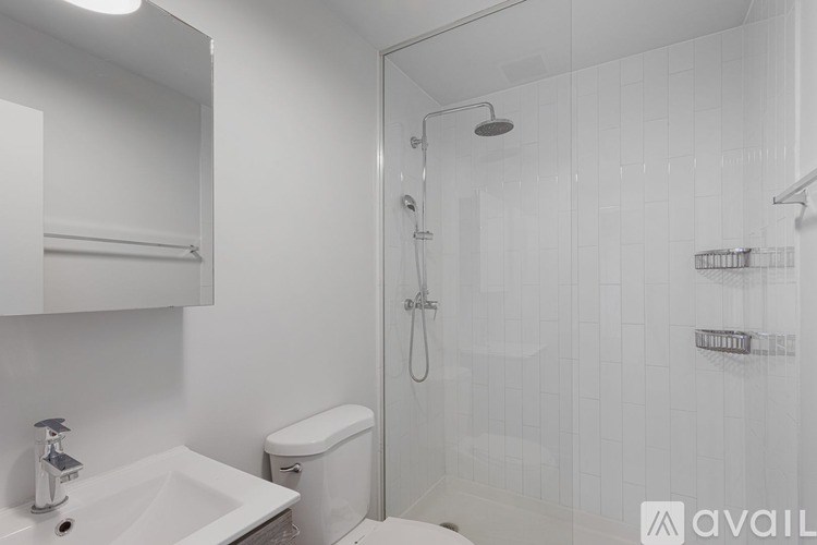 A white bathroom with a sink, toilet, and shower.