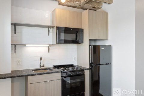 A kitchen with a black stove top oven and a black microwave above it.