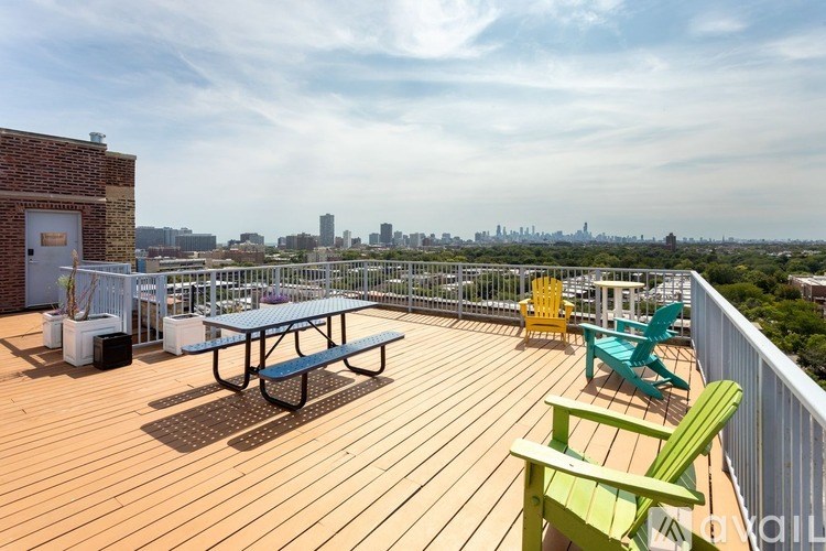 A wooden deck with a table and chairs overlooking a city skyline.