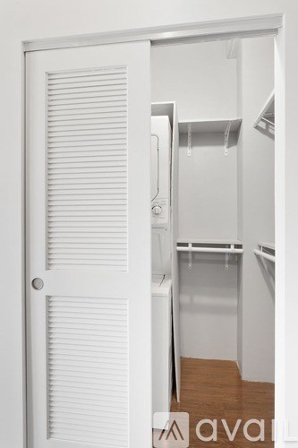 A white door is open to a small kitchen.