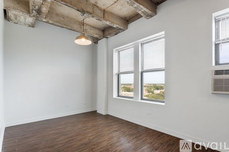 A room with wooden floors and a large window overlooking a cityscape.