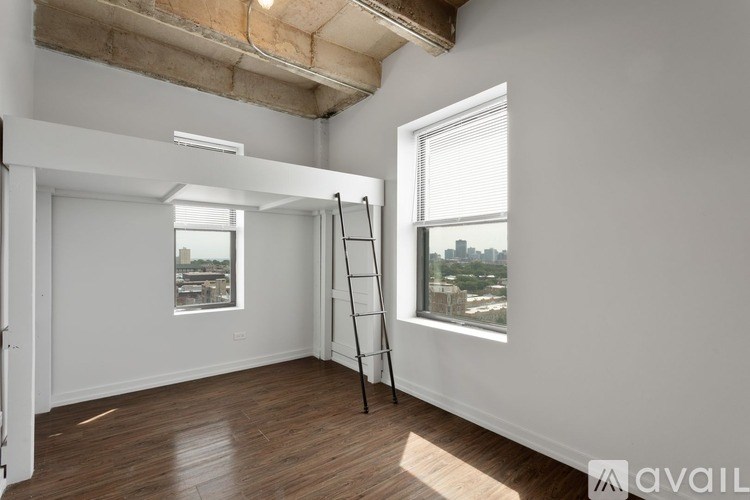 A room with a ladder and a window overlooking a cityscape.