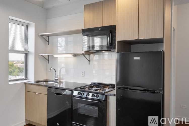A modern kitchen with black appliances and wooden cabinets.