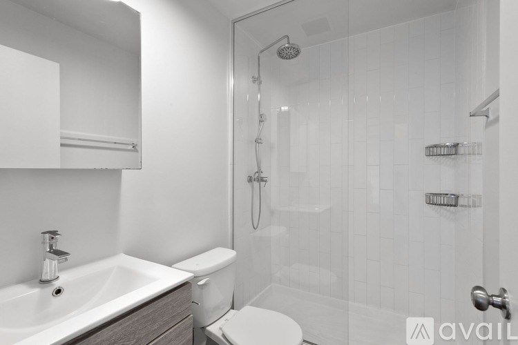 A bathroom with a white sink, toilet, and shower.