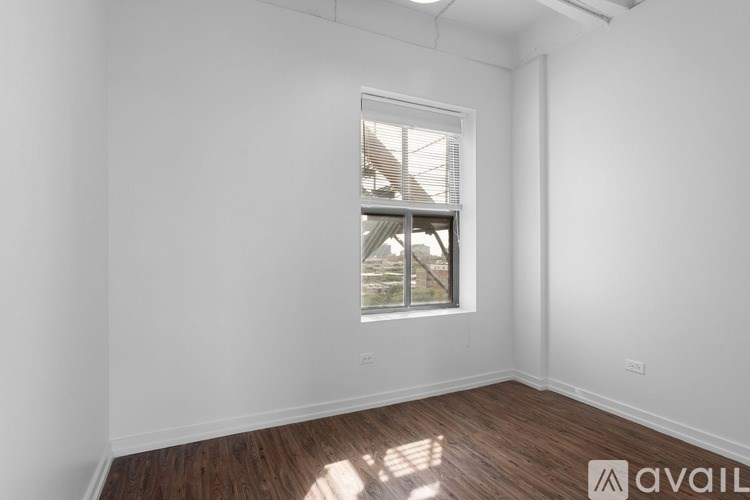 A room with a window and wooden flooring.