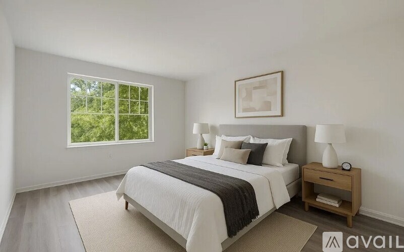 A bedroom with a large bed, a window, and a nightstand.
