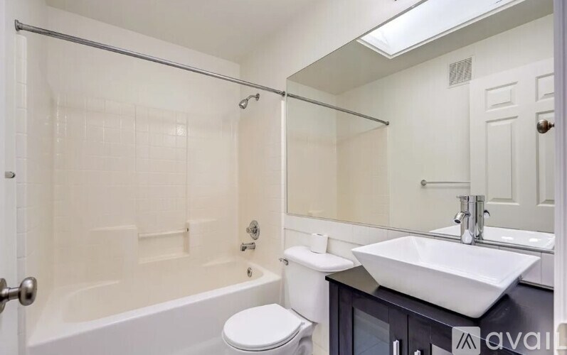 A white bathroom with a toilet, sink, and bathtub.