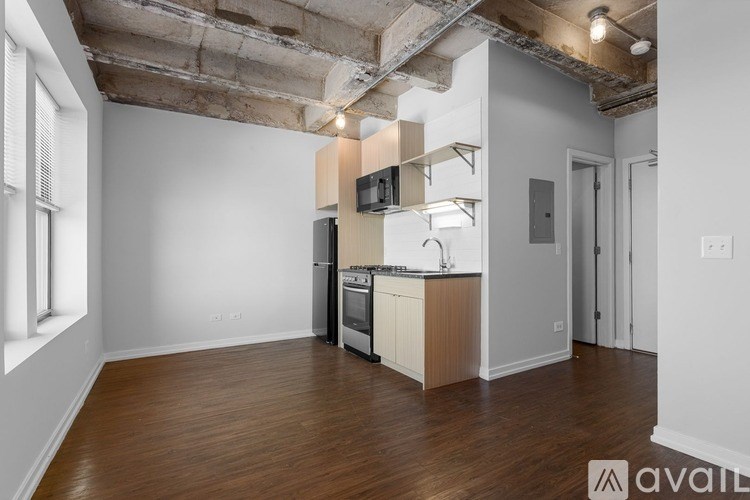 A kitchen area with wooden floors and a stainless steel dishwasher.