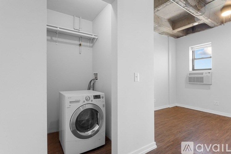A white washing machine is in a small laundry room.