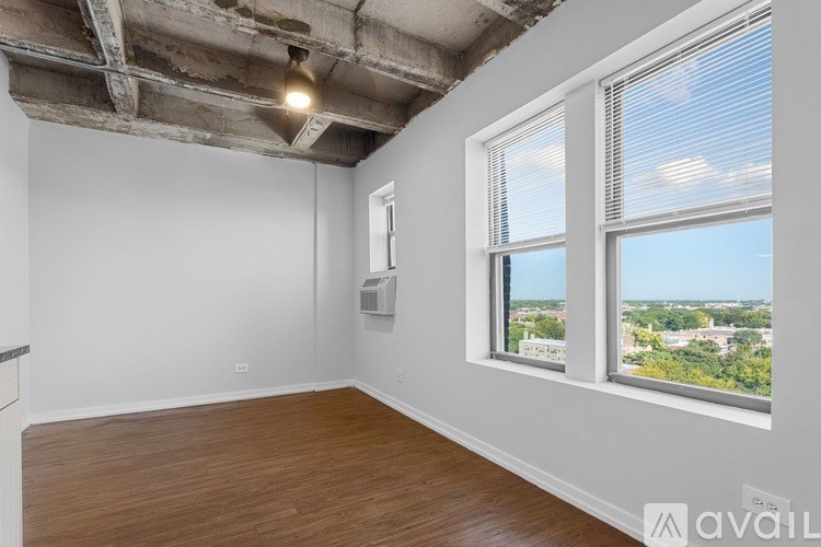 A room with a window overlooking a cityscape is available for rent.
