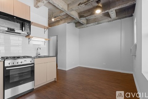 A kitchen with a stove top oven and a wooden floor.