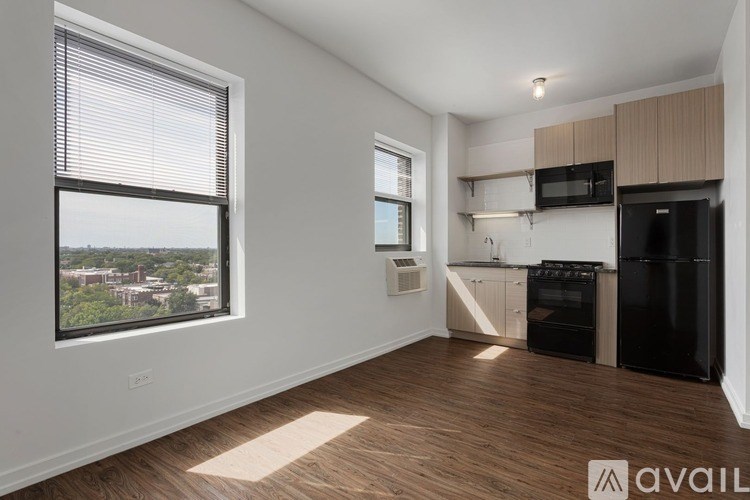 A kitchen area with black appliances and wooden flooring.