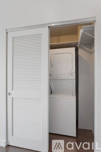 A white door is open to reveal a white washing machine.