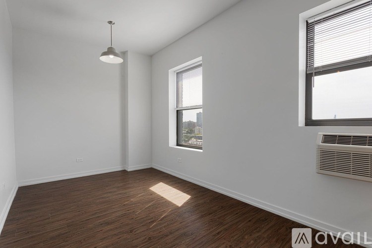 A room with wooden floors and a window showing a cityscape.