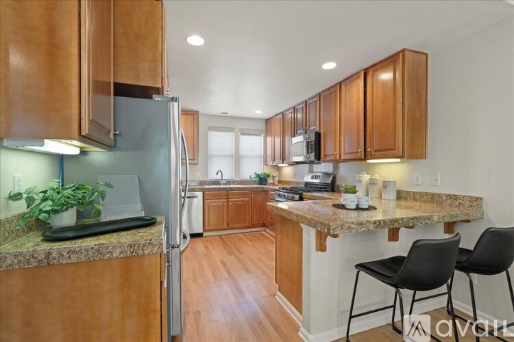 A kitchen with wooden cabinets and a granite countertop.
