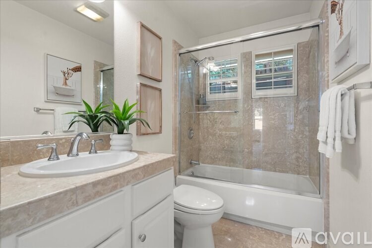 A bathroom with a sink, toilet, and shower.