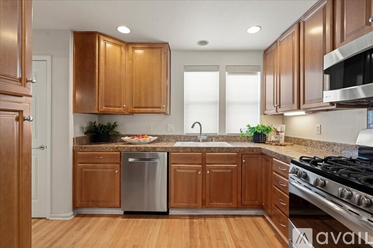 A kitchen with wooden cabinets and a stainless steel dishwasher.