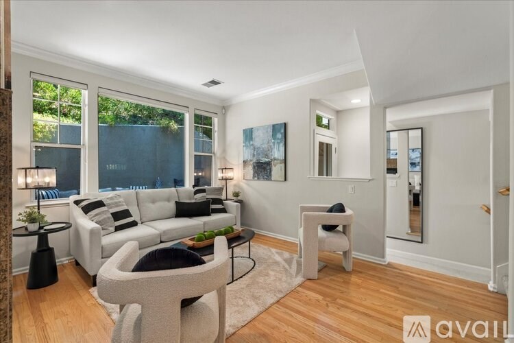 A living room with a white couch and a grey armchair.