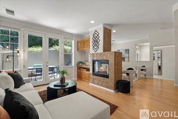 A modern living room with a fireplace and a glass table.