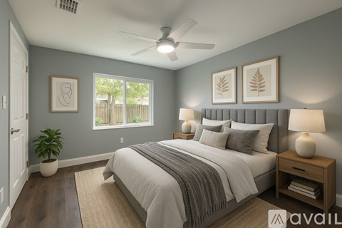 A bedroom with a bed, nightstand, and a plant.