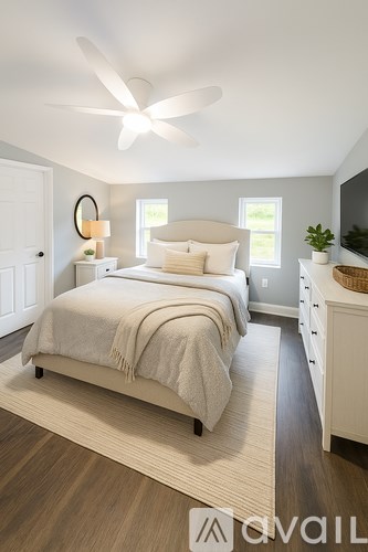 A bedroom with a bed, nightstand, and a ceiling fan.