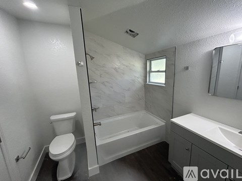A bathroom with a toilet, sink, and bathtub.