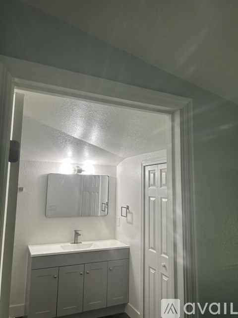 A bathroom with a white sink and a mirror above it.