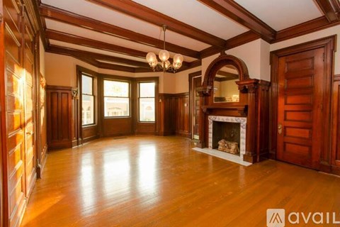 A large room with wooden floors and a fireplace.