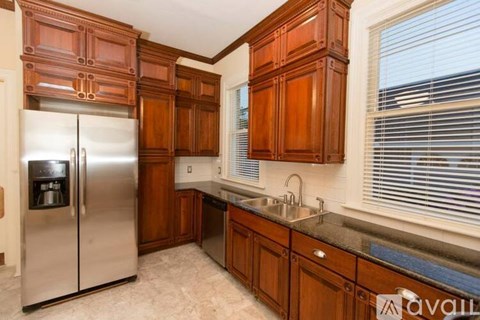 A kitchen with wooden cabinets and a stainless steel refrigerator.