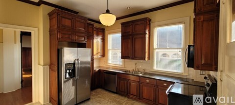 A kitchen with wooden cabinets and a stainless steel refrigerator.