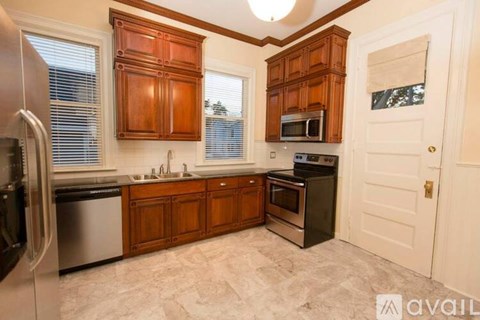 A kitchen with wooden cabinets and a black oven.