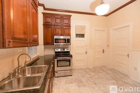 A kitchen with wooden cabinets and a stainless steel sink.